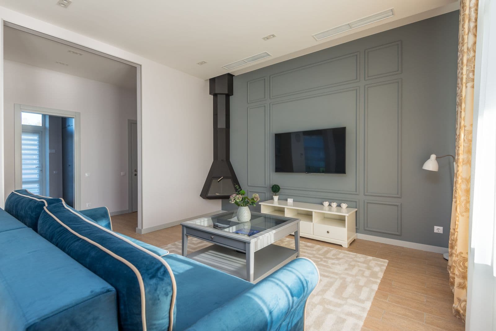 Bright living room with a grey-green feature wall